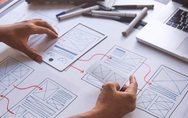 Mid-America Pool Renovation | Rsm Marketing Person working on website design prototypes with drawn diagrams and a laptop, representing expert seo and online advertising for hvac marketing agency.