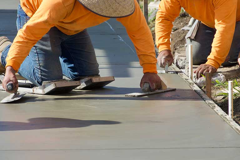Concrete contractors smoothing cement in daylight; RSM Marketing logo visible, showcasing effective lead generation marketing strategies for contractors.